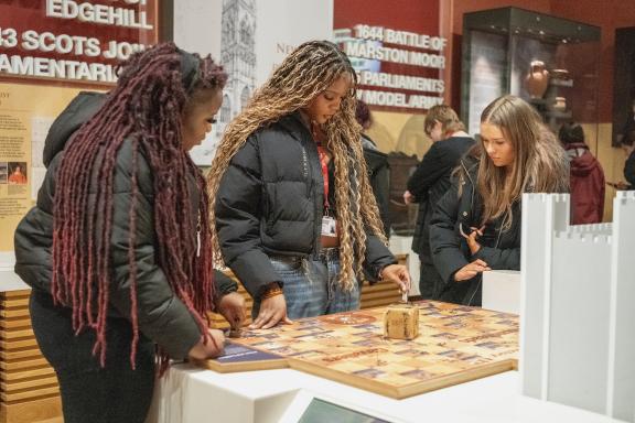 Three young people looking at an exhibit in a gallery