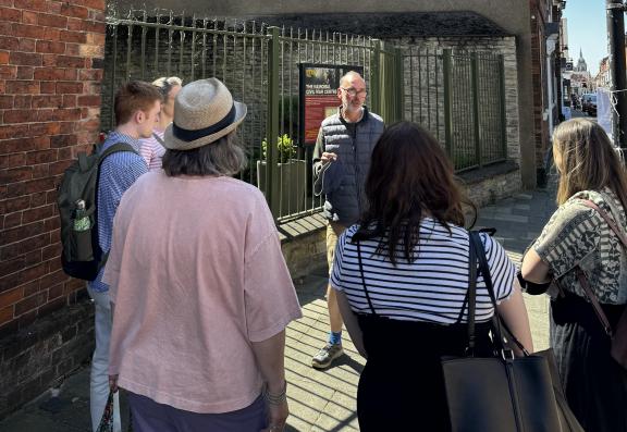 A tour guide speaking to a group of five people 