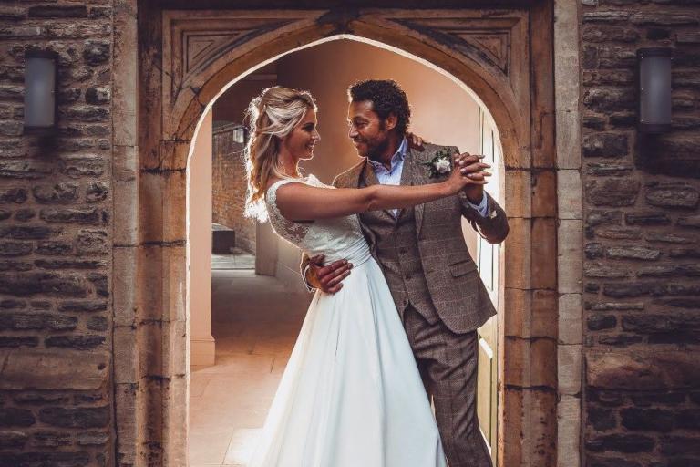 A man and a woman on their wedding day standing in a doorway 
