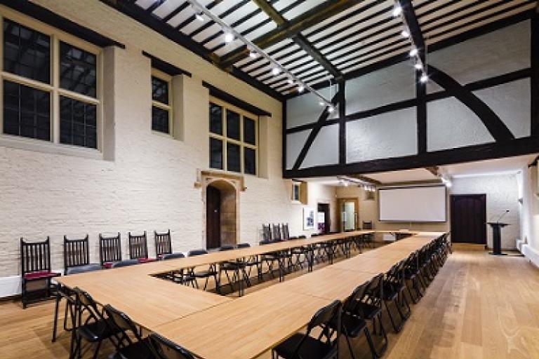 A large Tudor room with a table and exposed Tudor beams 