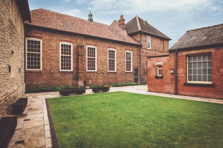 Buildings surrounding an outdoor grass courtyard