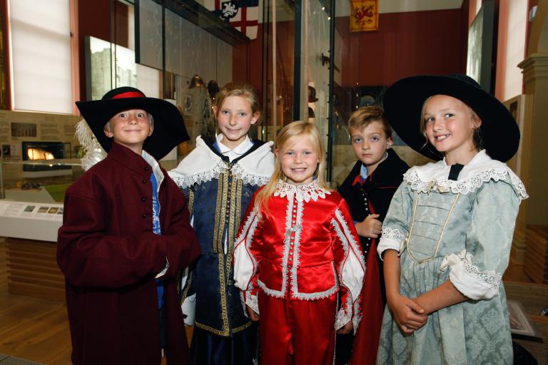 A group of 5 children dressed up in a gallery space 