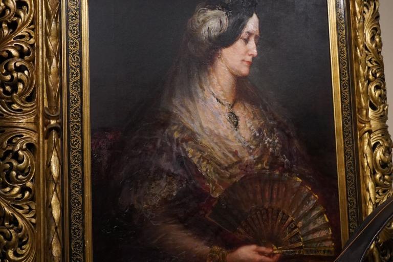 An historial painting of a lady with fan in a gold frame.