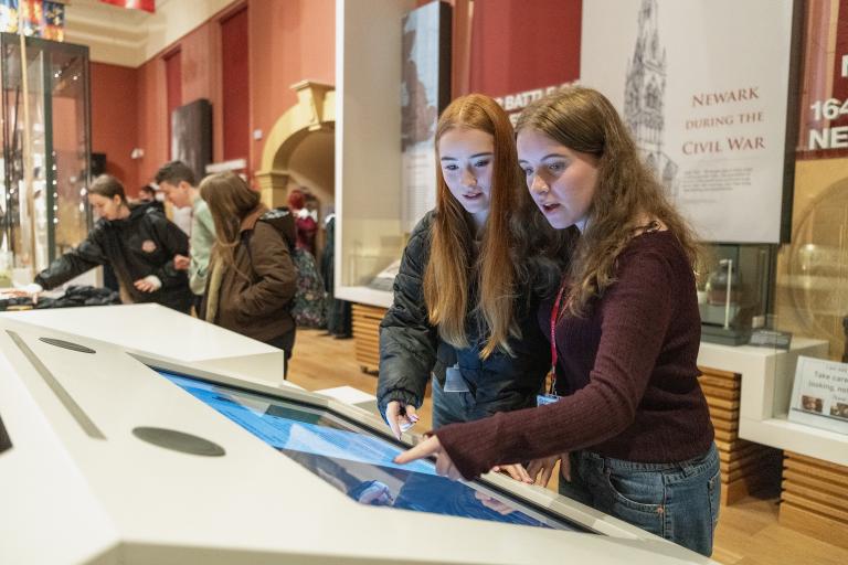 Two young people looking at a digital display in a gallery