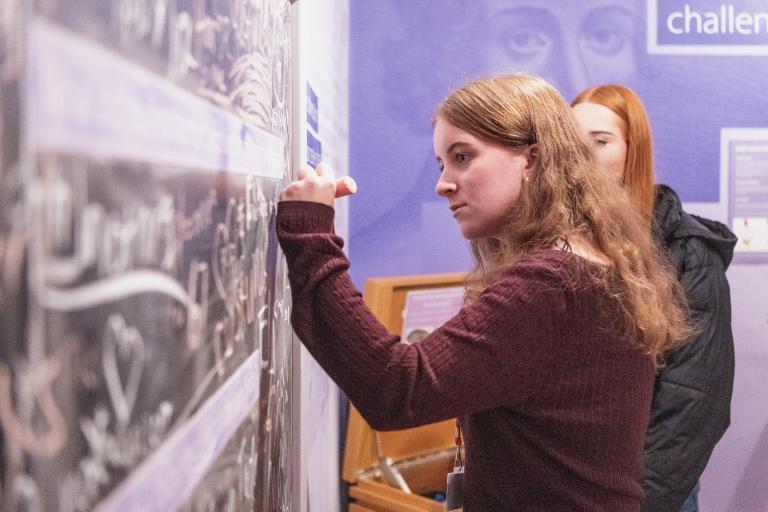 Two students writing on a board