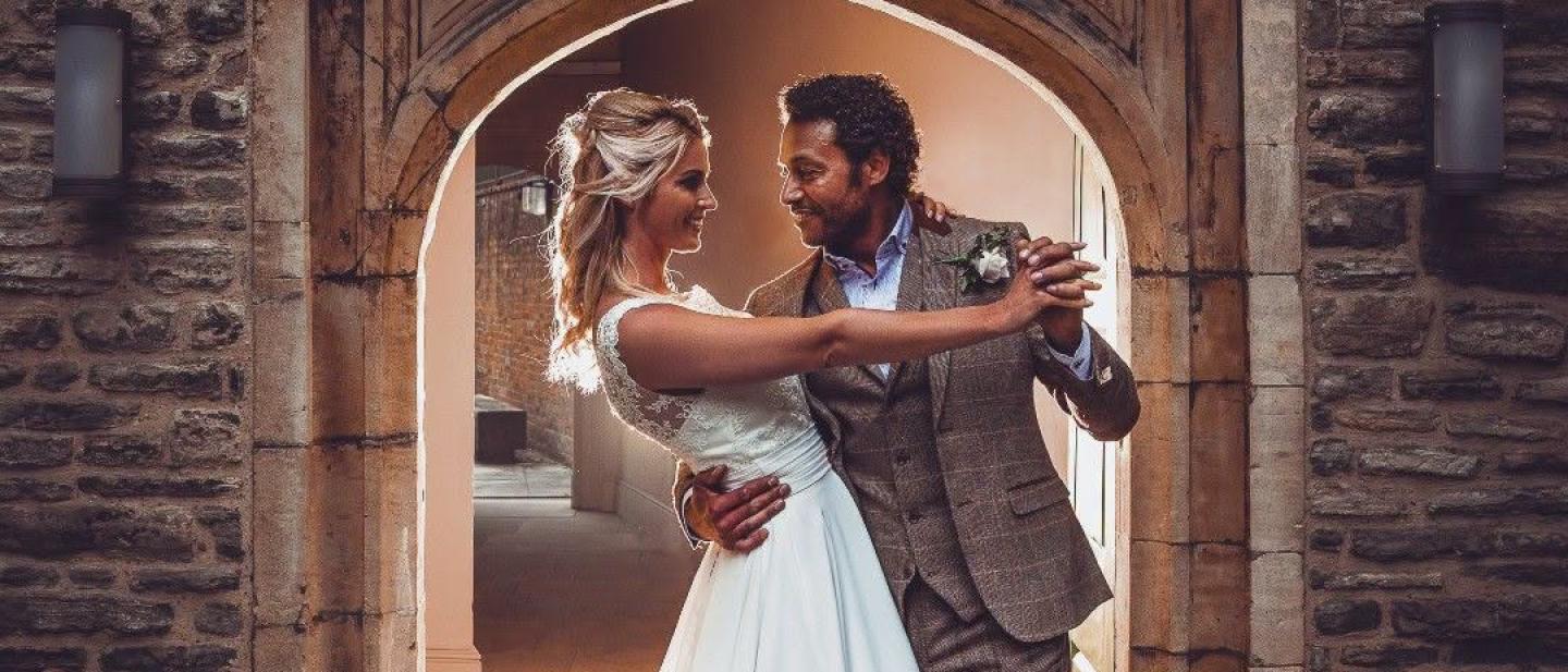 A man and a woman on their wedding day standing in a doorway 