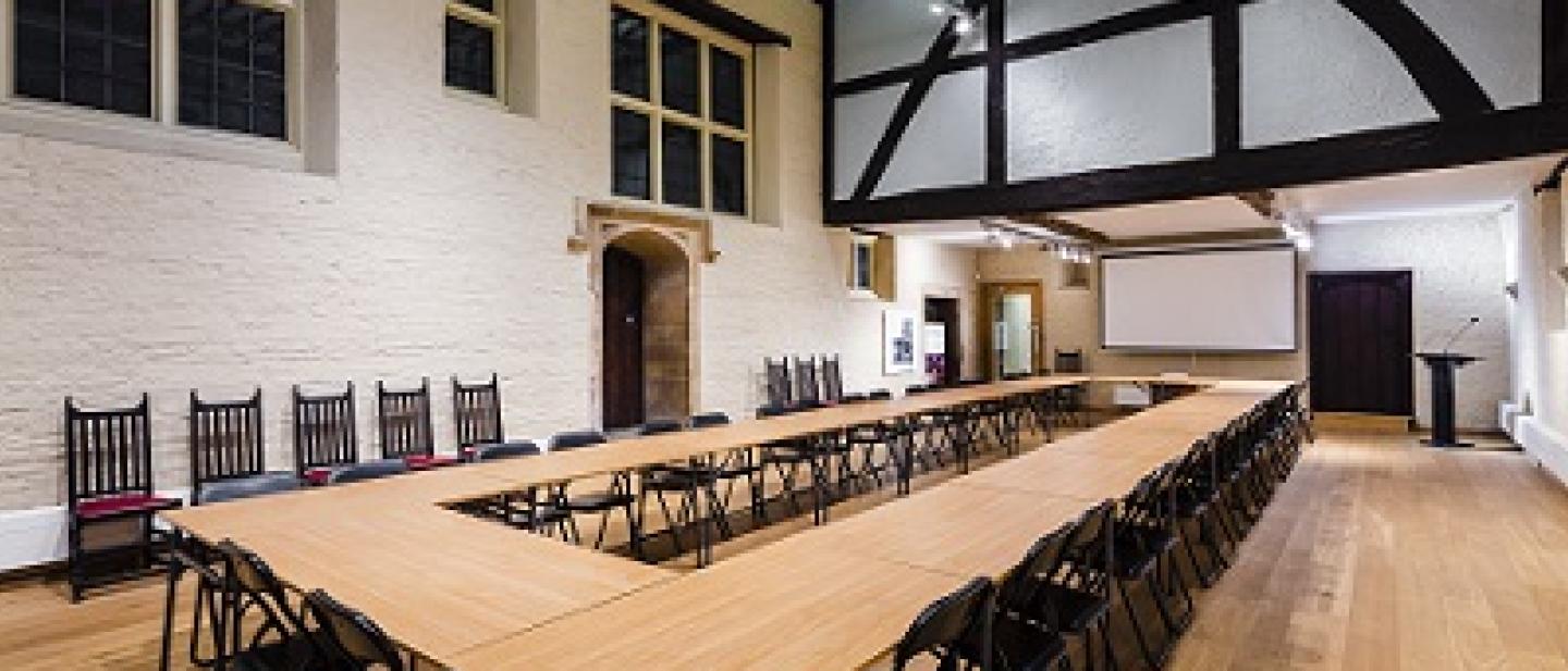 A large Tudor room with a table and exposed Tudor beams 