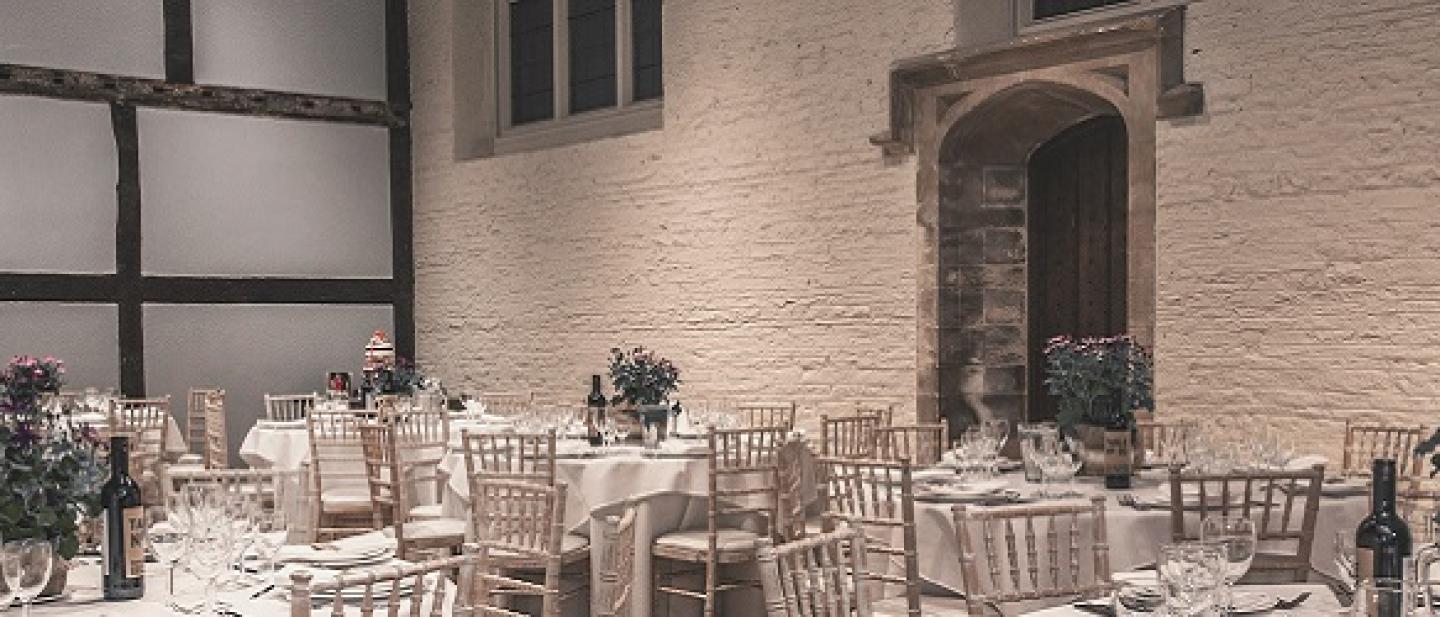 A Tudor style room with tables set for a wedding reception 