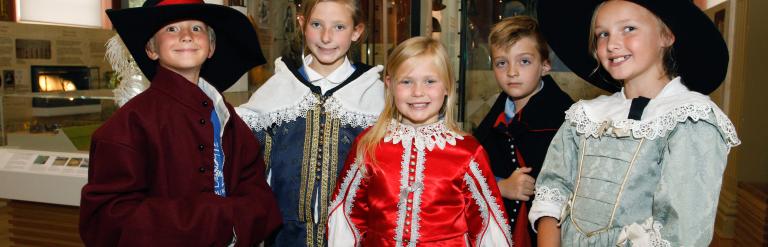 A group of 5 children dressed up in a gallery space 