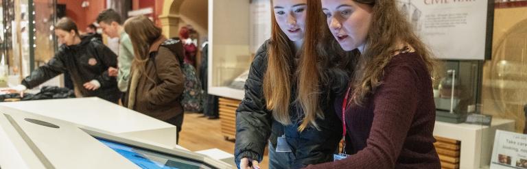 Two young people looking at a digital display in a gallery