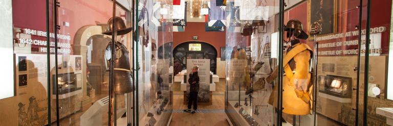 Objects, including suits of armour, in glass display cabinets in the Civil War gallery